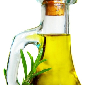 Closeup of olive oil and rosemary, isolated on white